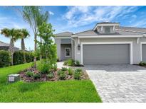Two-car garage and walkway of a new home with landscaping at 2638 Light Sky Ln, Bradenton, FL 34211