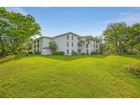 Low angle shot of a well-kept condominium and surrounding vibrant green lawn at 6304 Pointe West Blvd # A102, Bradenton, FL 34209