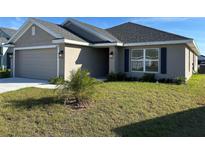 Charming single-story home featuring a well-maintained lawn and attached two-car garage at 2600 Averland Loop, North Port, FL 34287