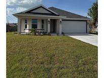 Charming single-story home with a well-manicured lawn, attached garage, and modern design elements, perfect for comfortable living at 664 Linden Rd, Venice, FL 34293