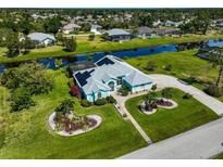 Aerial view of single-story home with pool, canal views, and lush landscaping at 51 Marker Rd, Rotonda West, FL 33947