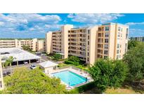 Condo complex featuring a refreshing community swimming pool and meticulously maintained landscaping at 4410 Fairways Blvd # 406, Bradenton, FL 34209
