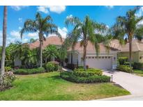 Luxury home with a tile roof, lush landscaping, and a paved driveway at 13853 Siena Loop, Lakewood Ranch, FL 34202