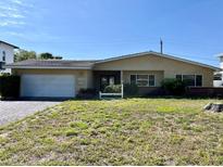 Charming one-story home featuring an attached garage and a well-maintained front yard at 6613 Blue Heron S Dr, St Petersburg, FL 33707
