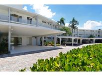 Modern building with covered parking and lush landscaping at 100 Sands Point Rd # 324, Longboat Key, FL 34228
