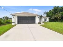 Charming single-story home showcasing a well-manicured lawn and a spacious two-car garage at 2511 Stagnaro Rd, North Port, FL 34287