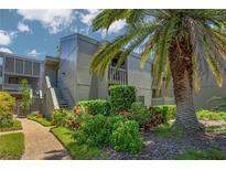 Condo building with lush landscaping and walkway at 207 Woodland Dr # 207, Osprey, FL 34229