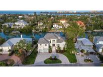 Beautiful aerial view of waterfront home with circular driveway and lush landscaping at 3550 Flamingo Ave, Sarasota, FL 34242