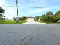 Single-Gathering home with a two car garage and tropical landscaping at 2760 Chipley Ave, North Port, FL 34286