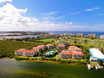 Aerial view of waterfront community with resort-style pool and lush landscaping at 360 Gulf Of Mexico Dr # 322, Longboat Key, FL 34228