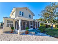 Charming yellow house with a screened porch and landscaped yard at 1810 28Th W St, Bradenton, FL 34205