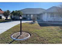 Single-story home with a landscaped lawn and driveway at 1706 Wolf Laurel Dr, Sun City Center, FL 33573