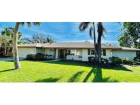 Charming single-story home featuring lush landscaping and mature palm trees at 3637 Mineola Dr, Sarasota, FL 34239