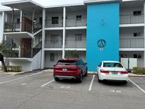 Condo building with white balconies and a blue accent wall with parking spaces at 5906 Garden Ln # A22, Bradenton, FL 34207