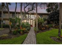 Two-story condo building, brick paver pathway, lush landscaping at 3438 Wood Owl Cir # 275, Bradenton, FL 34210