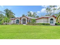 Stunning home showcasing a well-manicured lawn and beautiful landscaping at 7430 Weeping Willow Dr, Sarasota, FL 34241