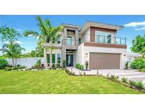 Stunning two-story modern home featuring clean lines, balcony, lush landscaping, and an attached two-car garage at 1805 Goldenrod St, Sarasota, FL 34239