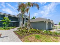 Modern building with walkway, landscaping, and attached garage at 12520 Galapagos Ct # 207, Venice, FL 34293