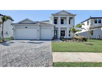 Two-story home with a three-car garage and a landscaped front yard at 2605 Waterfront Cir, Sarasota, FL 34240