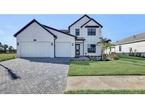 Two-story house with white exterior, gray driveway, and landscaping at 2625 Waterfront Cir, Sarasota, FL 34240
