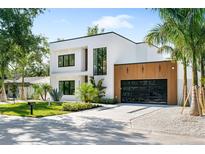 Striking modern home featuring clean lines, wood accents, and a sleek, glass-door garage at 2226 Grove St, Sarasota, FL 34239