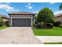 House exterior featuring a gray garage door and manicured lawn at 13202 Torresina Ter, Bradenton, FL 34211