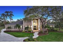 Stunning two-story brick home featuring a manicured lawn, elegant columns, and a grand entrance at 6722 Oakmont Way, Lakewood Ranch, FL 34202