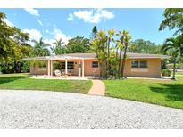 Charming ranch-style home with a pergola-covered patio and mature landscaping at 3225 Duncan Way, Sarasota, FL 34239