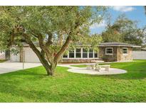 Charming ranch-style home with stone accents and a manicured lawn at 907 E Rosedale Rd, Venice, FL 34293