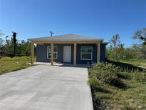 Charming single-story home with a modern blue exterior, covered porch, and newly paved driveway at 1211 30Th W Ave, Bradenton, FL 34205