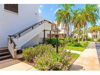 Exterior of condo building with tropical landscaping, stairs, and walkway at 255 Sherwood Dr # 255U, Bradenton, FL 34210