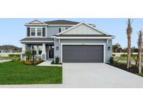Charming two-story home with gray siding, manicured lawn, and a two-car garage at 7016 Foxboro Way, Nokomis, FL 34275