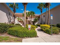 Two-story building exterior with lush landscaping and a central courtyard fountain at 4244 Central Sarasota Pkwy # 725, Sarasota, FL 34238