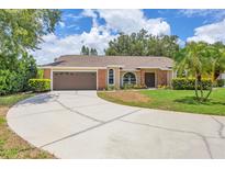 Charming single-story home with a large driveway and a well-manicured lawn with mature trees and landscaping at 4709 Foy Pl, Sarasota, FL 34243