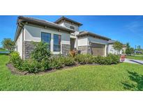 Beautiful one-story home featuring stone accents, a two-car garage, and a well-maintained lawn and landscaping at 429 Alberata Way, Nokomis, FL 34275