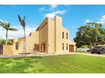 Two-story yellow house with a large yard, palm trees, and a detached garage at 6515 Mauna Loa Blvd, Sarasota, FL 34241