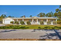 Charming single-story home featuring a columned front porch and a well-manicured lawn at 3125 Pickett St, Port Charlotte, FL 33981