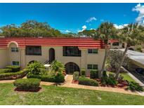 Condo building with red tile roof and lush landscaping at 213 Rubens Dr # D, Nokomis, FL 34275