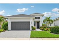 Modern single-story home with two-car garage and landscaped yard at 5244 Barnett Cir, Lakewood Ranch, FL 34211