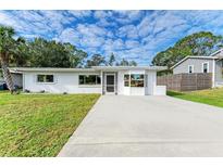 Charming single-story home with a well-manicured lawn and concrete driveway at 818 Padgett Ave, Sarasota, FL 34237