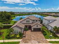 Luxury home with lake view, paver driveway, and basketball court at 6358 Rivo Lakes Blvd, Sarasota, FL 34241