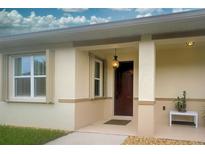 Inviting home entrance features a charming pineapple light fixture, neutral paint, and covered entry at 8930 Tuscany Isles Dr, Punta Gorda, FL 33950