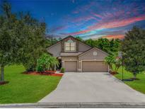 Charming home boasts a well-manicured lawn, mature trees, and a two-car garage, creating an inviting curb appeal at 5919 Lexington Dr, Parrish, FL 34219