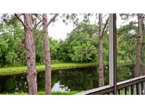 Tranquil water view from screened porch, overlooking a peaceful pond and lush greenery at 4751 Travini Circle # 4-116, Sarasota, FL 34235