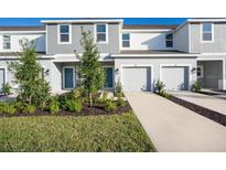 Two-story townhome with gray siding, two-car garage, and landscaping at 3153 Novara Ln, Lakewood Ranch, FL 34211