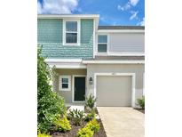 Two-story townhome with teal and beige siding and a two-car garage at 3051 Novara Ln, Lakewood Ranch, FL 34211