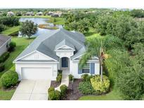 Beautiful home featuring a well-manicured lawn and a lovely view of a tranquil lake in the background at 11406 Belvedere Ter, Lakewood Ranch, FL 34211
