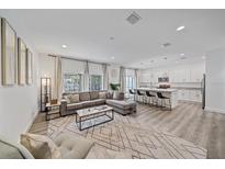 Open-concept living room with a modern kitchen and a large sectional sofa at 1807 Robinhood St, Sarasota, FL 34231