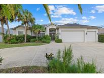 Charming single-story home featuring a three-car garage and lush tropical landscaping at 974 Rotonda Cir, Rotonda West, FL 33947