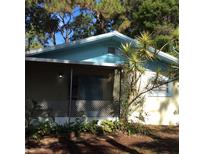 Inviting light-blue home with screened porch and lush landscaping at 4020 Murdock Ave, Sarasota, FL 34231